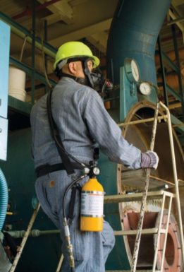 man wearing yellow MSA 10065044-SP 15 Minute Carbon 3000 psi Cylinder with Valve Assembly